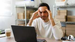 Imprenditore disperato al computer che si chiede perché il suo sito web non porta clienti e cerca soluzioni